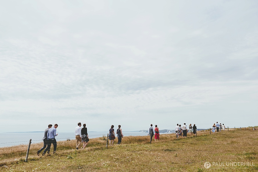 Wedding guests walk over the coast path